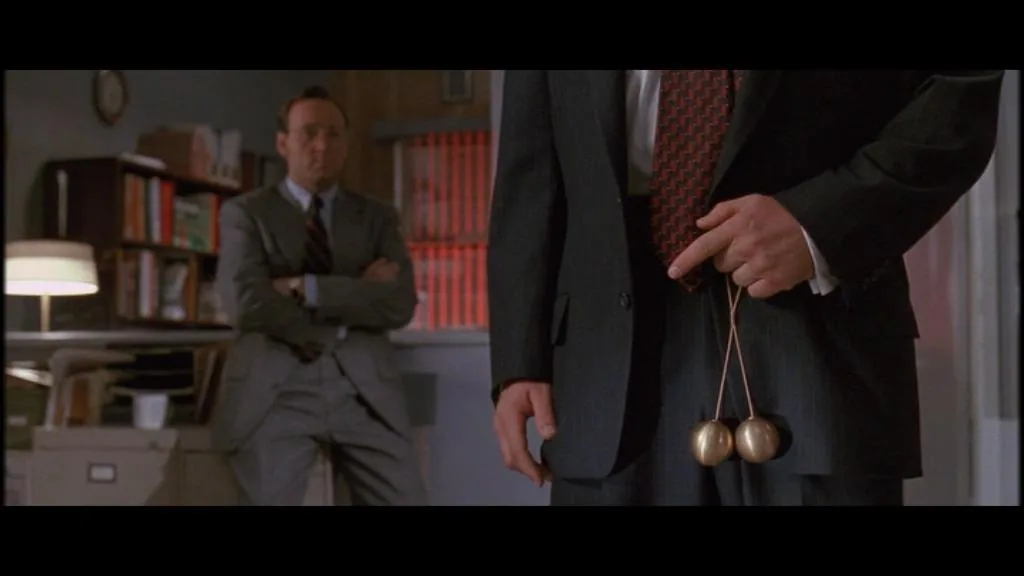 Alec Baldwin holding up a pair of brass balls in Glengarry Glen Ross